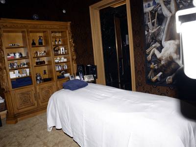 File:EFTA00000167 - Luxurious spa room features a massage table ornate wooden shelves stocked with skincare products and an artful wall mural.jpg
