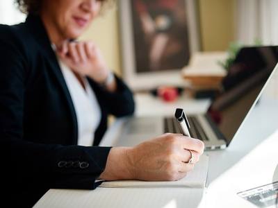 File:Business professional engages in note-taking during a meeting at a modern office desk.jpg