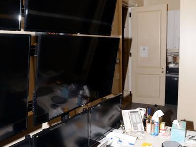 File:EFTA00000865 - Modern office workspace featuring multiple monitors on a wall a laptop on a desk and a cluttered yet functional setup.jpg