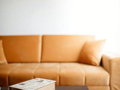 File:Cozy living room setup with a warm sofa, coffee cup, and an open book in a softly lit environment.jpg