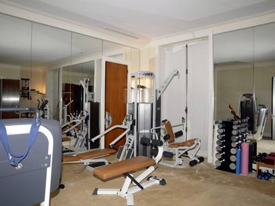 File:EFTA00000256 - Well-equipped home gym featuring various exercise machines free weights and mats arranged neatly against mirrored walls.jpg