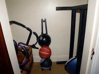 File:EFTA00000264 - Small home gym corner featuring exercise equipment medicine balls and a weight bench against a wall.jpg