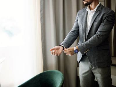 File:Businessman adjusts his shirt cuff while in a hotel room.jpg