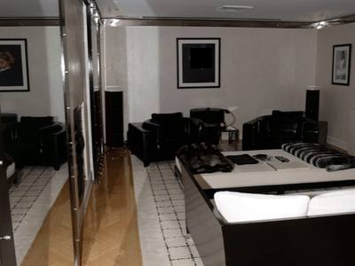 File:EFTA00001218 - Modern living room with black leather furniture a patterned rug and mirrored walls reflecting the space.jpg