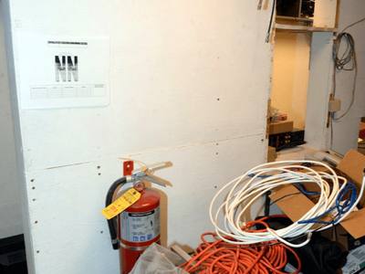 File:EFTA00001297 - Construction site workspace with a fire extinguisher coiled cables tools and a wall-mounted sign.jpg