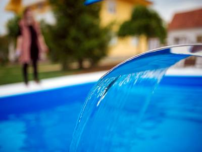 File:A modern swimming pool with a water feature pouring water into the pool closeup.jpg