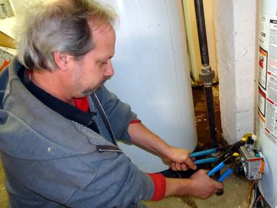 File:Plumber uses two wrenches to tighten a fitting.jpg
