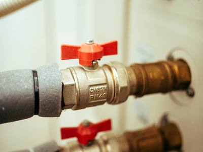 File:Plumbing valves and pipes in a utility room with connections in focus.jpg