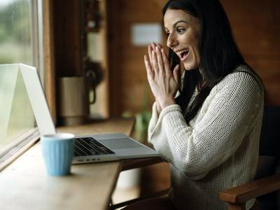 File:Happy woman enjoying video call inside cabin with laptop and coffee cup.jpg